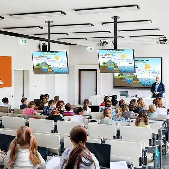 Trong một lớp học lớn chứa đầy học sinh, màn hình WAD 75 inch trung tâm phản chiếu nội dung giáo dục lên các màn hình nhỏ hơn gắn trên trần nhà, đảm bảo khả năng hiển thị cho tất cả mọi người thông qua kết nối HDMI.